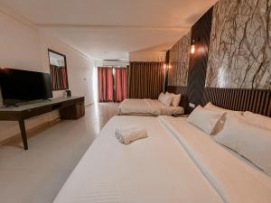 a large bedroom with two beds and a desk at Hotel Elephant Park - Most Elephant Bathing View Rooms in Pinnawala in Pinnawala