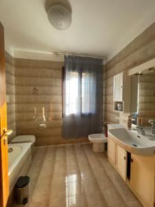 a bathroom with a sink and a tub and a toilet at Casa Rustica - Camere in Torri di Quartesolo