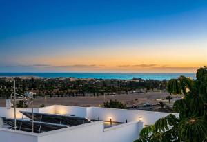 a view of the ocean from a building at VillasRoyale Rex - no steps, easy access, heated pool & BBQ in Meloneras