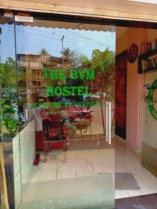 a window of a restaurant with a reflection of a table at The BVM Hostel in Mumbai