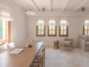 a living room with a wooden table and chairs at Om Living Pelion in Agios Dimitrios