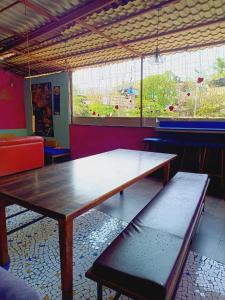 a table and bench in a room with a large window at The BVM Hostel in Mumbai
