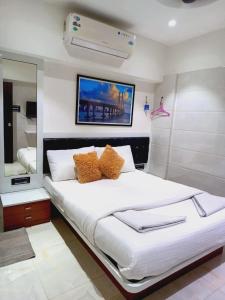 a bedroom with a large white bed and a mirror at The BVM Hostel in Mumbai +26 photos