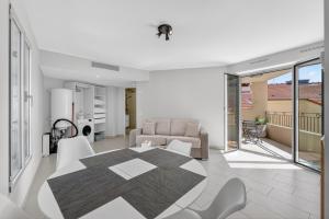 a living room with a table and a couch at 1 chambre - Ascenseur - Balcon - Proche du Palais in Cannes +13 photos