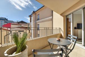 a balcony with a table and chairs and a view at 1 chambre - Ascenseur - Balcon - Proche du Palais in Cannes