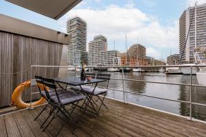 a table and chairs on a balcony with a view of a river at Houseboat-Oostende in Ostend