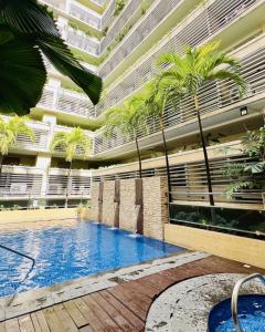 a large building with a swimming pool and palm trees at Henry's Newport Condotel in Manila
