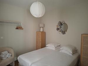 a bedroom with a white bed and a mirror at Appartement Jehan de Beauce in Chartres