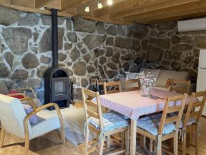 a dining room with a table and a stone wall at Serena Nest 02 in Cabeceiras de Basto