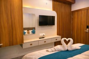 a hotel room with a bed with swans in front of a mirror at Hotel Mariott Inn in Prayagraj