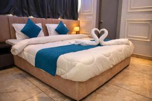 a bed with two swans shaped towels on it at Hotel Mariott Inn in Prayagraj