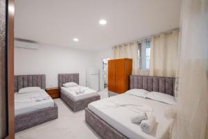 a bedroom with two beds and a mirror at Vila Myrtaj in Ksamil