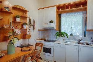 a kitchen with white cabinets and a table and a sink at Villa Sofias in Pefkochori +55 photos