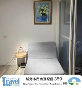 a small bedroom with a bed and a table at Shan Cheng Guesthouse in Ruifang