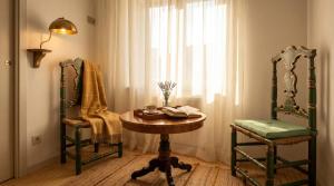 a room with a table and two chairs and a window at Edoardo Historic House in Gubbio
