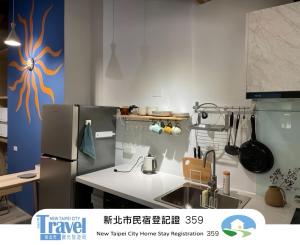 a kitchen with a sink and a refrigerator at Shan Cheng Guesthouse in Ruifang +2 photos