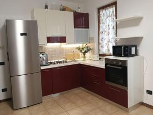 a kitchen with brown cabinets and a stainless steel refrigerator at Casa Maribel in Salionze