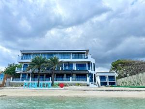 a building on the beach next to the water at PlayaLolita Beach Resort in Calatagan