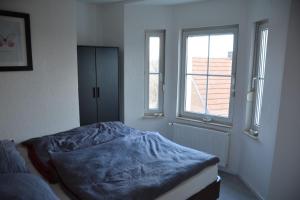 a bedroom with a bed with a blue blanket on it at Zur Eresburg in Marsberg