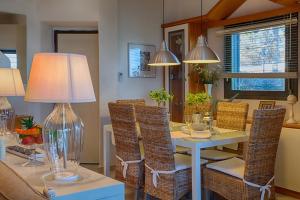 a dining room with a table with chairs and a lamp at Villa Sofias in Pefkochori