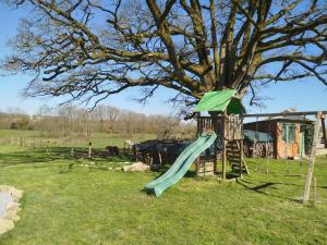 a playground with a slide next to a tree at Maisonnette de charme A 5 min du Parc PUYDUFOU in Les Épesses +19 photos