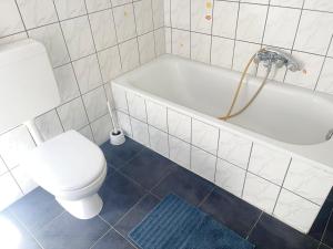a white bathroom with a toilet and a tub at AC01-AC06 Apartment in Herzogenrath in Herzogenrath