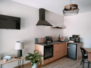 a kitchen with a sink and a stove top oven at Maisonnette de charme A 5 min du Parc PUYDUFOU in Les Épesses