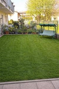 a green yard with a bench in the grass at Casa Maribel in Salionze +3 photos
