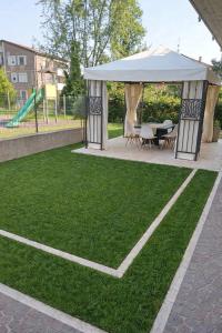 a gazebo with a table and chairs on a lawn at Casa Maribel in Salionze