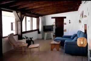 a living room with a blue couch and a tv at El aceitunal private pool in Puerto del Rosario