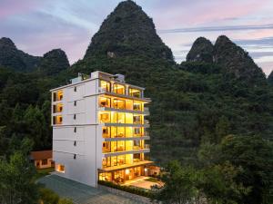a building in front of a mountain at Yangshuo Xishan Resort in Yangshuo