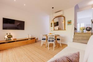 a living room with a table and a tv at Laranjal Rive Gauche in Tavira