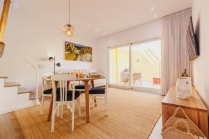 a dining room and living room with a table and chairs at Laranjal Rive Gauche in Tavira