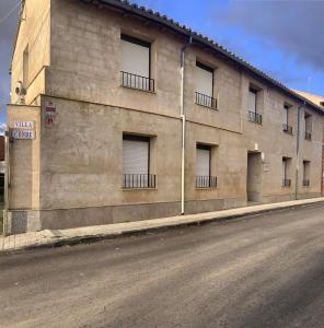 a building with windows on the side of a street at Villa Conde, Piscina, Barbacoa y Gran Patio in Prado