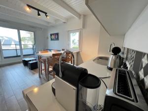 a kitchen with a counter and a dining room with a table at Ty Bihan plage 4p in Carnac +6 photos