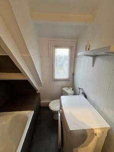 a white bathroom with a sink and a toilet at Ty Bihan plage 4p in Carnac