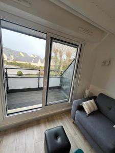 a living room with a couch and a large window at Ty Bihan plage 4p in Carnac