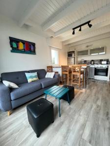 a living room with a blue couch and a table at Ty Bihan plage 4p in Carnac