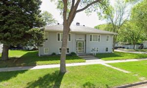 a white house with a tree in the yard at Economy 3 beds in Moorhead