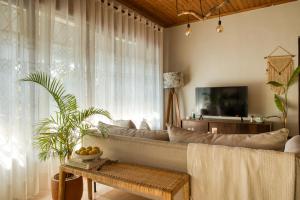 a living room with a couch and a tv at The Garden Home in Arusha