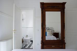 a bedroom with a mirror and a bathroom with a toilet at Casa Camelia - Cathedral View Apartment, 90m from Duomo in Noto