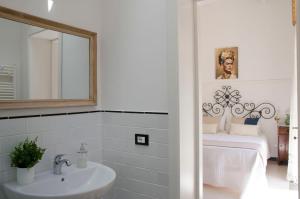 a white bathroom with a sink and a mirror at Casa Camelia - Cathedral View Apartment, 90m from Duomo in Noto