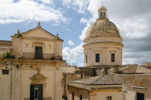 an old building with a dome on top of it at Casa Camelia - Cathedral View Apartment, 90m from Duomo in Noto