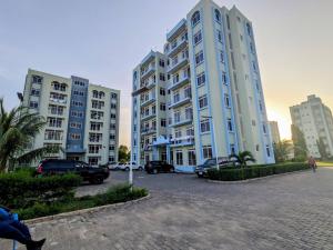 a group of tall buildings in a parking lot at Zanzi modern 2 bed apartment GF in Zanzibar City
