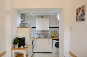 a kitchen with white cabinets and a washer and dryer at Casa Camelia - Cathedral View Apartment, 90m from Duomo in Noto +32 photos