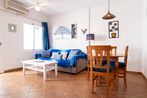a living room with a blue couch and a table at Sirius in La Isleta del Moro +9 photos