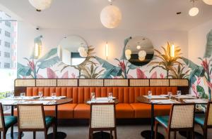 a dining room with tables and chairs and a mural at MK Colombo in Colombo