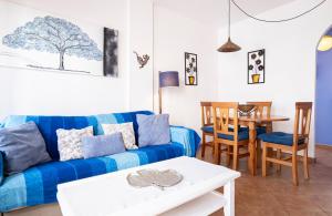 a living room with a blue couch and a table at Sirius in La Isleta del Moro
