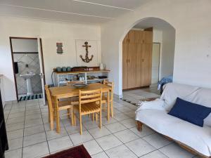a living room with a table and a couch at Driftwood Haven in Mossel Bay