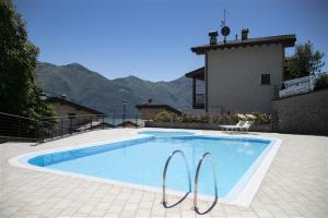 a swimming pool with two chairs next to a house at IseoLakeRental - Casa Lani in Costa Volpino
